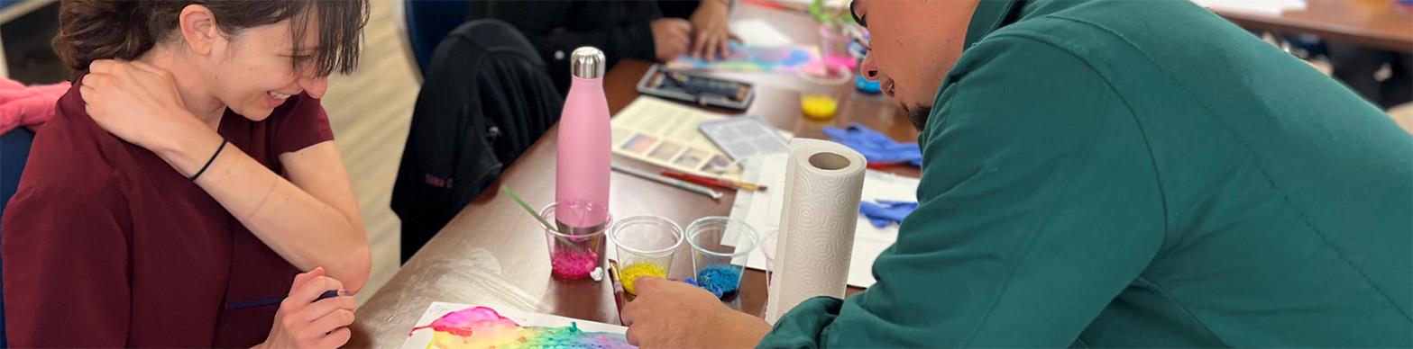 Two individuals pouring over a visual artwork